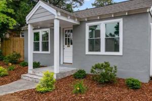 a gray house with a white door and windows at Updated, Fenced, Pet Friendly Downtown Cottage in Southern Pines +10 photos