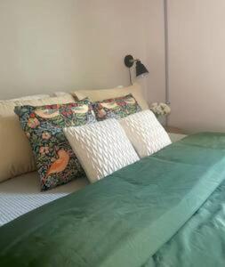 a bed with two pillows on top of it at Updated, Fenced, Pet Friendly Downtown Cottage in Southern Pines