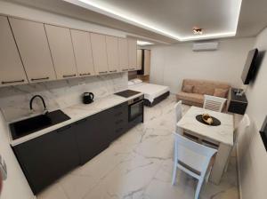 a kitchen and living room with a couch and a table at Merlin Prestige Apartments in Budva