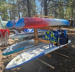 a group of kayaks and backpacks on a rack at Beautiful Riverfront Near Mt Bachelor with Hot Tub in Bend