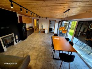 a living room with a table and chairs and a fireplace at Domek nad jeziorem in Skępe