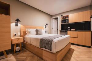 a bedroom with a large bed and a kitchen at Second Home Río Po in Mexico City