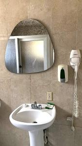 a bathroom with a sink and a mirror at Coconut Tree West Bay in West Bay