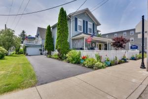 a blue house with an american flag in the driveway at Prime Lakeside Village Location Apt with Kitchen! in Bemus Point