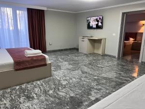 a hotel room with a bed and a desk at MAV Beach Villa in Eforie Nord