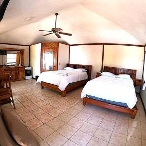 a bedroom with two beds and a ceiling fan at Coconut Tree West Bay in West Bay
