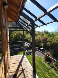 a wooden deck with a view of a garden at Hogar de Montaña in San Martín de los Andes +17 photos