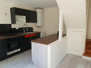 a kitchen with black and white cabinets and a counter at Maison à Issy les Moulineaux, proche de Paris in Issy-les-Moulineaux