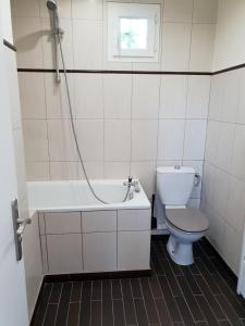 a bathroom with a toilet and a tub and a sink at Maison à Issy les Moulineaux, proche de Paris in Issy-les-Moulineaux +4 photos