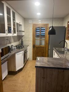 a kitchen with white cabinets and a wooden floor at Casa Natales- Patagonia House in Puerto Natales