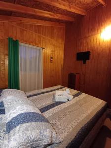 una camera da letto con un letto con asciugamani sopra di Cabaña en Frutillar a Frutillar