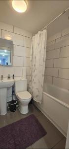 a bathroom with a toilet and a sink and a tub at Deluxe Town Centre 2 Bedroom Apartment in Stevenage +16 photos