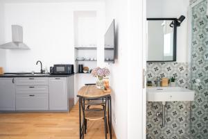 a kitchen with a table with a vase of flowers on it at Wally Apartments by Flat White - With Elevator in Zagreb +26 photos