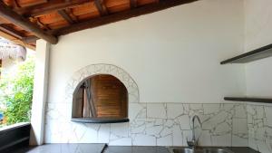 a kitchen with a sink and a wall with a window at Linda Casa no coração do Centro Histórico in Porto Seguro