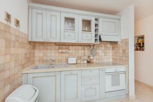 a kitchen with white cabinets and a sink at Manor Pastrovici in Budva