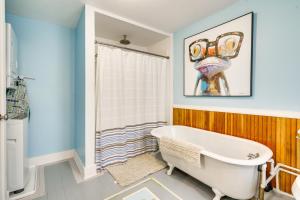 a bathroom with a tub and a painting on the wall at Prime Lakeside Village Location Apt with Kitchen! in Bemus Point +18 photos