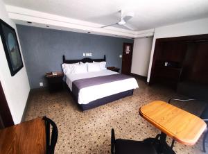 a hotel room with a bed and a table and chair at Hotel Habana in Mexico City