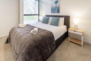 a bedroom with a large bed and a window at Modern 2 Bed 2 Bath Opposite Hagley Park in Christchurch