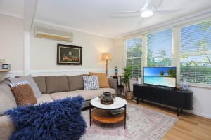 a living room with a couch and a flat screen tv at Bella Luca Pet Friendly Home in Hawks Nest