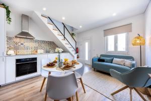 una cucina e un soggiorno con un tavolo e un divano blu di Casa Clara a Vila do Bispo