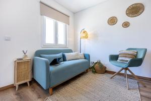 un soggiorno con un divano blu e una sedia di Casa Clara a Vila do Bispo
