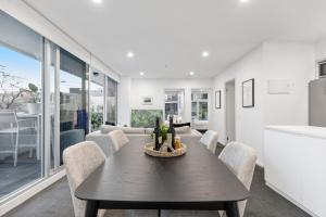una cucina e una sala da pranzo con tavolo e sedie di Sleek South Yarra 2-Bed with Alfresco Dining a Melbourne