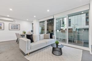 un soggiorno con un divano e un tavolo di Sleek South Yarra 2-Bed with Alfresco Dining a Melbourne