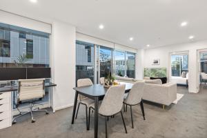 una cucina e un soggiorno con tavolo e sedie di Sleek South Yarra 2-Bed with Alfresco Dining a Melbourne