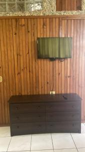 a television on top of a dresser in a room at Coconut Tree West Bay in West Bay