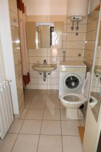 a small bathroom with a toilet and a sink at Apartments with parking space Senj - 15376 in Senj +37 photos
