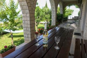 a bottle of wine on a wooden table with two wine glasses at Apartments with parking space Senj - 15376 in Senj