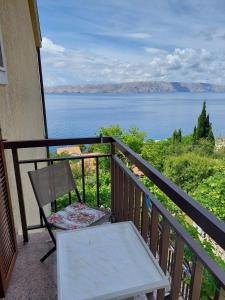 a chair and a table on a balcony with a view of the water at Apartments with parking space Senj - 15376 in Senj