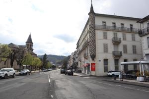 a city street with cars parked on the side of a building at 201, Les Ambassadeurs in La Bourboule