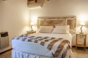 a bedroom with a large bed with two night stands at Samai Suma Cabañas & Spa in Villa General Belgrano