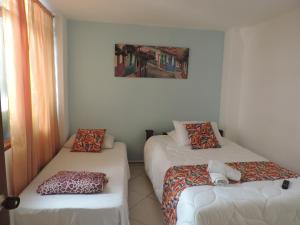 a room with two beds and a couch at Hotel San Juan Guatape in Guatapé +4 photos