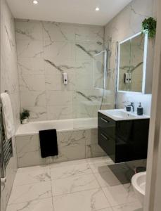 une salle de bain avec une baignoire, un lavabo et une douche dans l'établissement Stylish Madison Apartment with Balcony - FREE Car Parking - Hemel Hempstead Town Centre, à Hemel Hempstead 33 autres photos