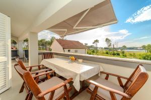 a dining room with a table and chairs on a balcony at Apartments with parking space Privlaka, Zadar - 23472 in Privlaka