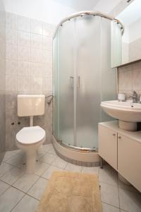 ein Badezimmer mit Dusche, Toilette und Waschbecken in der Unterkunft Apartments by the sea Stara Novalja, Pag - 21662 in Stara Novalja + 53 Fotos