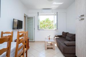 ein Wohnzimmer mit einer Couch und einem Fenster in der Unterkunft Apartments by the sea Stara Novalja, Pag - 21662 in Stara Novalja