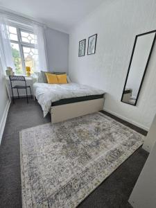 a bedroom with a bed with a rug and a mirror at Beautiful rooms in PRIME location! in London