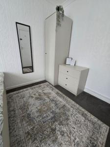 a room with a dresser and a mirror and a rug at Beautiful rooms in PRIME location! in London