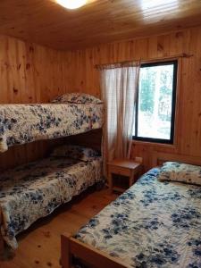 a bedroom with two bunk beds and a window at Cabañas villa ojen la pinta número 4 in Caburgua