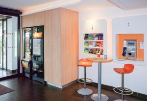 a bar with two stools and a cash register at ibis budget Castelnaudary - A61 in Castelnaudary