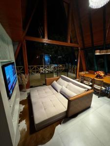 een woonkamer met een bank en een televisie bij Chalé e refúgio dos sonhos! Conheça o Kleines Paradies in Massaranduba +20 foto's