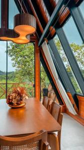 een eetkamer met een tafel, stoelen en ramen bij Chalé e refúgio dos sonhos! Conheça o Kleines Paradies in Massaranduba