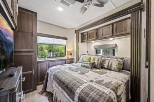 a bedroom with a bed and a tv at Creekside Glamping Resort- Fishing Pond, Mini Golf, Game Room, Pet Friendly in Gatlinburg