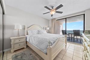 a bedroom with a bed with a ceiling fan and a balcony at Bluewater Unit 404 in Orange Beach