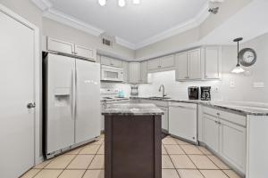a kitchen with white cabinets and a refrigerator at Bluewater Unit 404 in Orange Beach +51 photos