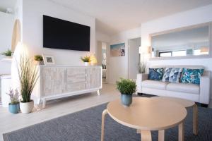 ein Wohnzimmer mit Sofa und Tisch in der Unterkunft Peaceful River Front Escape Short walk to Ocean St in Maroochydore