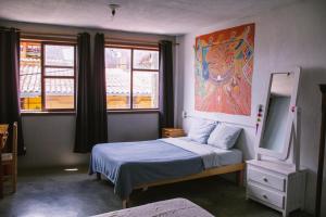 a bedroom with two beds and a painting on the wall at Casa Satoshi in San Cristóbal de Las Casas